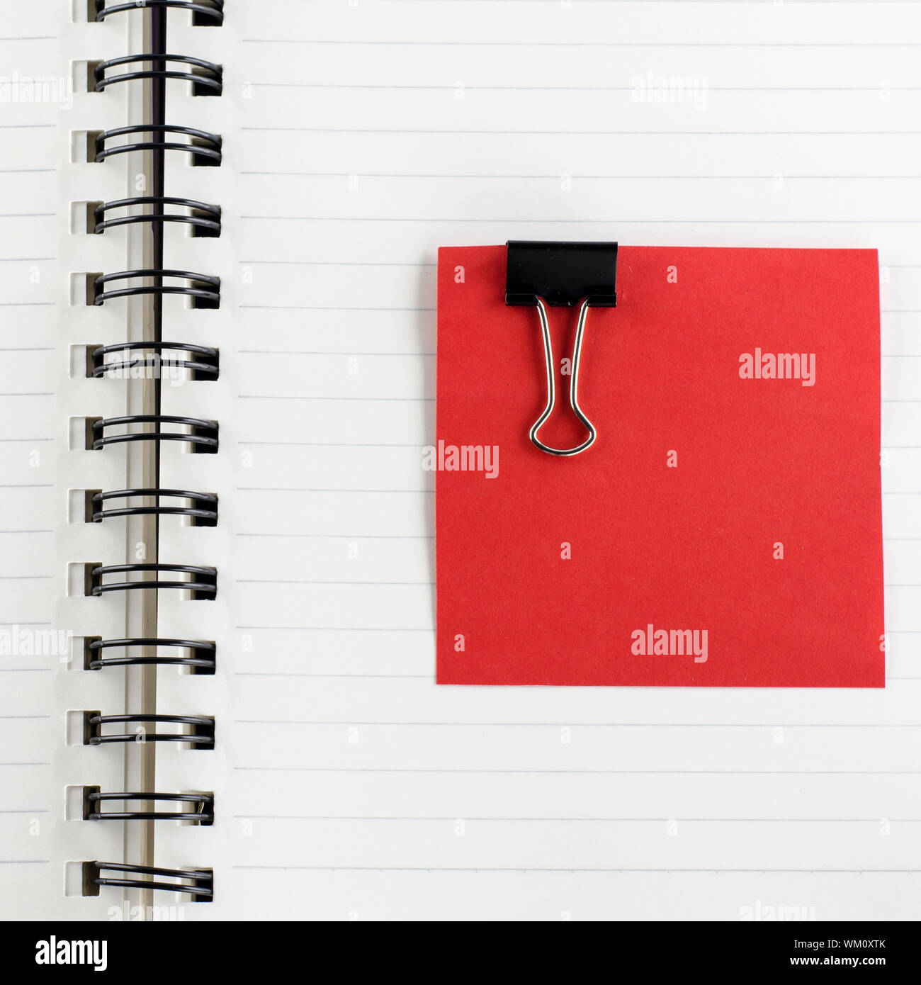 red paper note with black clip on notebook Stock Photo - Alamy