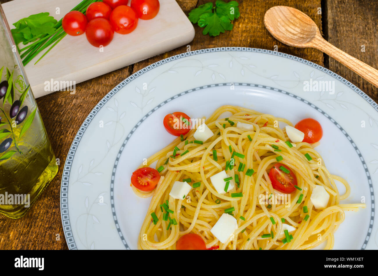 Spaghetti with cherry tomatoes and mozzarella, olive oil Stock Photo