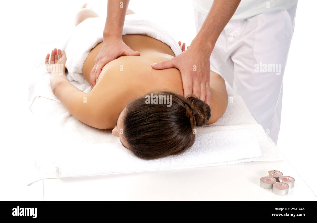 Female hands do a back massage to a man in the salon. Stock Photo by puhimec