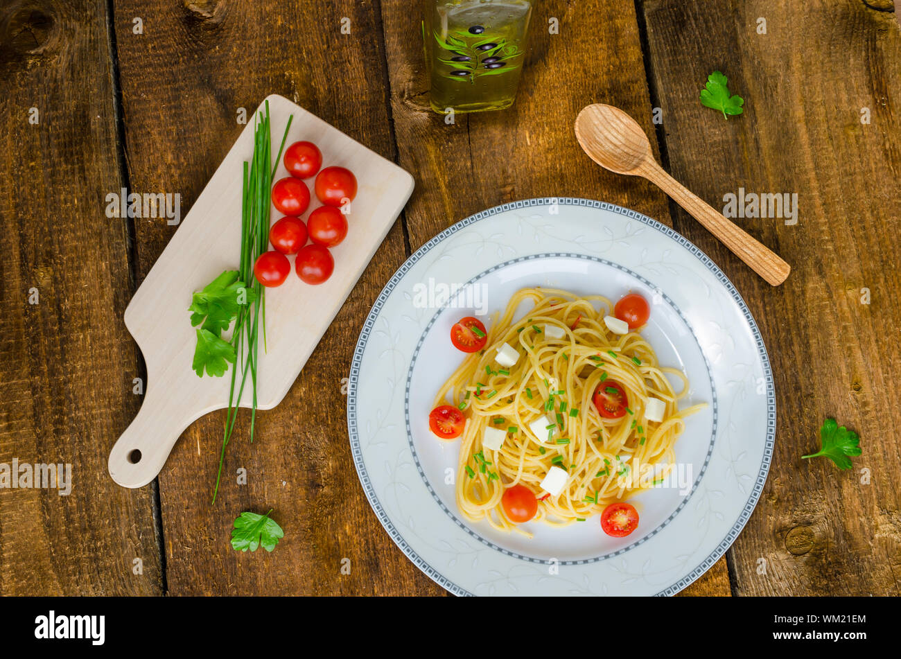 Spaghetti with cherry tomatoes and mozzarella, olive oil Stock Photo