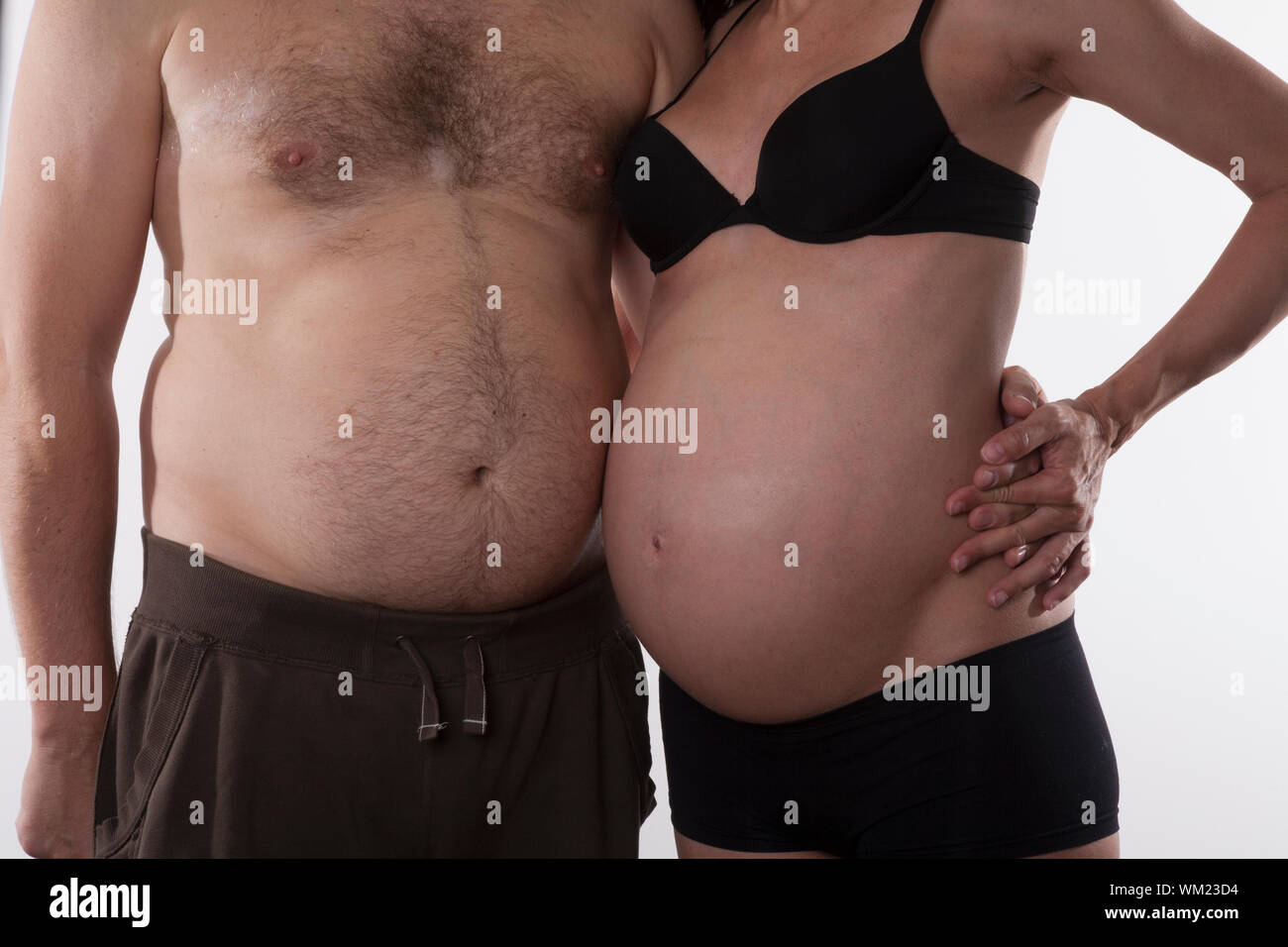 embraced pregnant woman and fat man on white background Stock Photo - Alamy