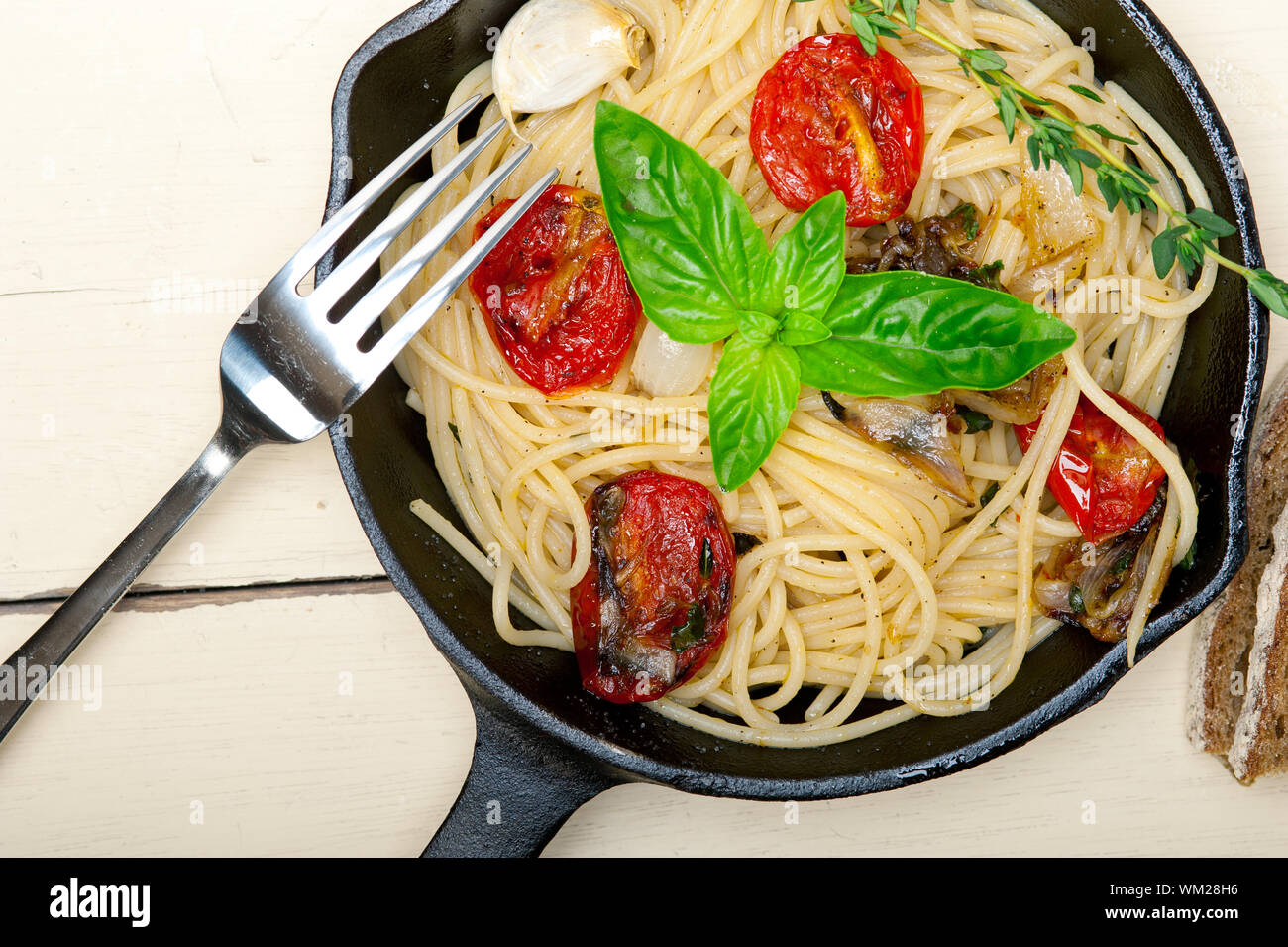 italian spaghetti pasta with baked tomatoes basil and thyme sauce on a
