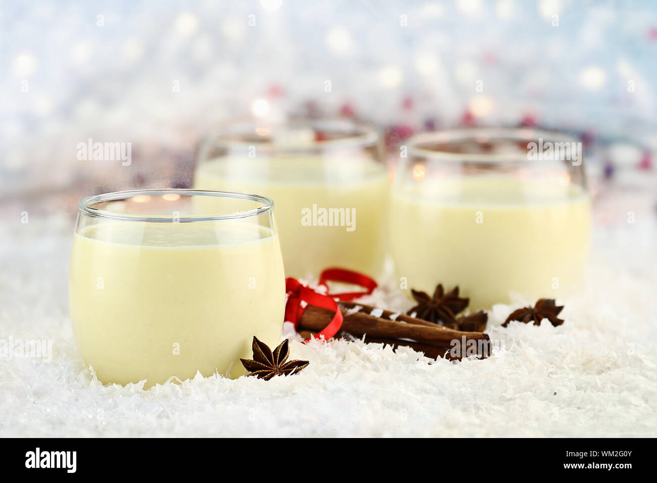 Three glasses of fresh eggnog with cinnamon sticks and star of anise ...