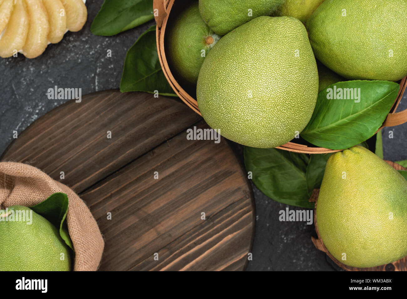 Fresh pomelo,grapefruit in bamboo basket with green leaf on dark 