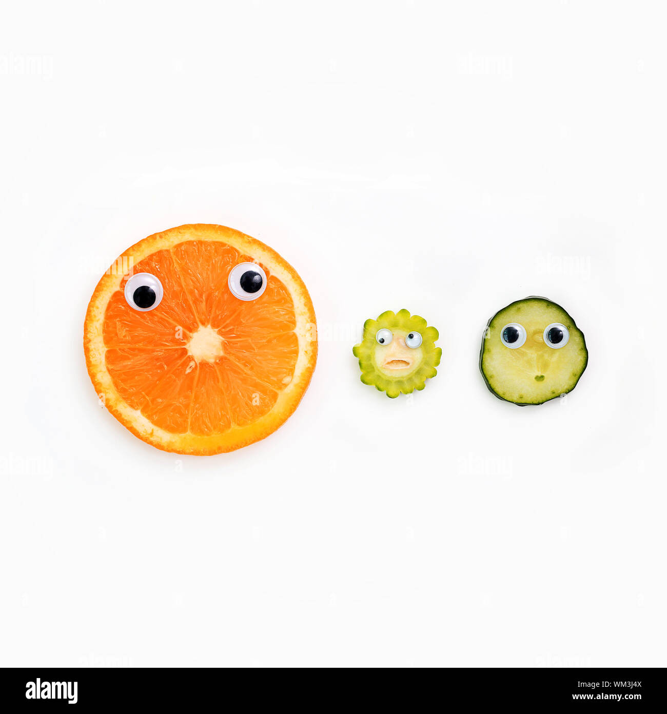 Directly Above Shot Of Googly Eyes On Food Slices Over White Background