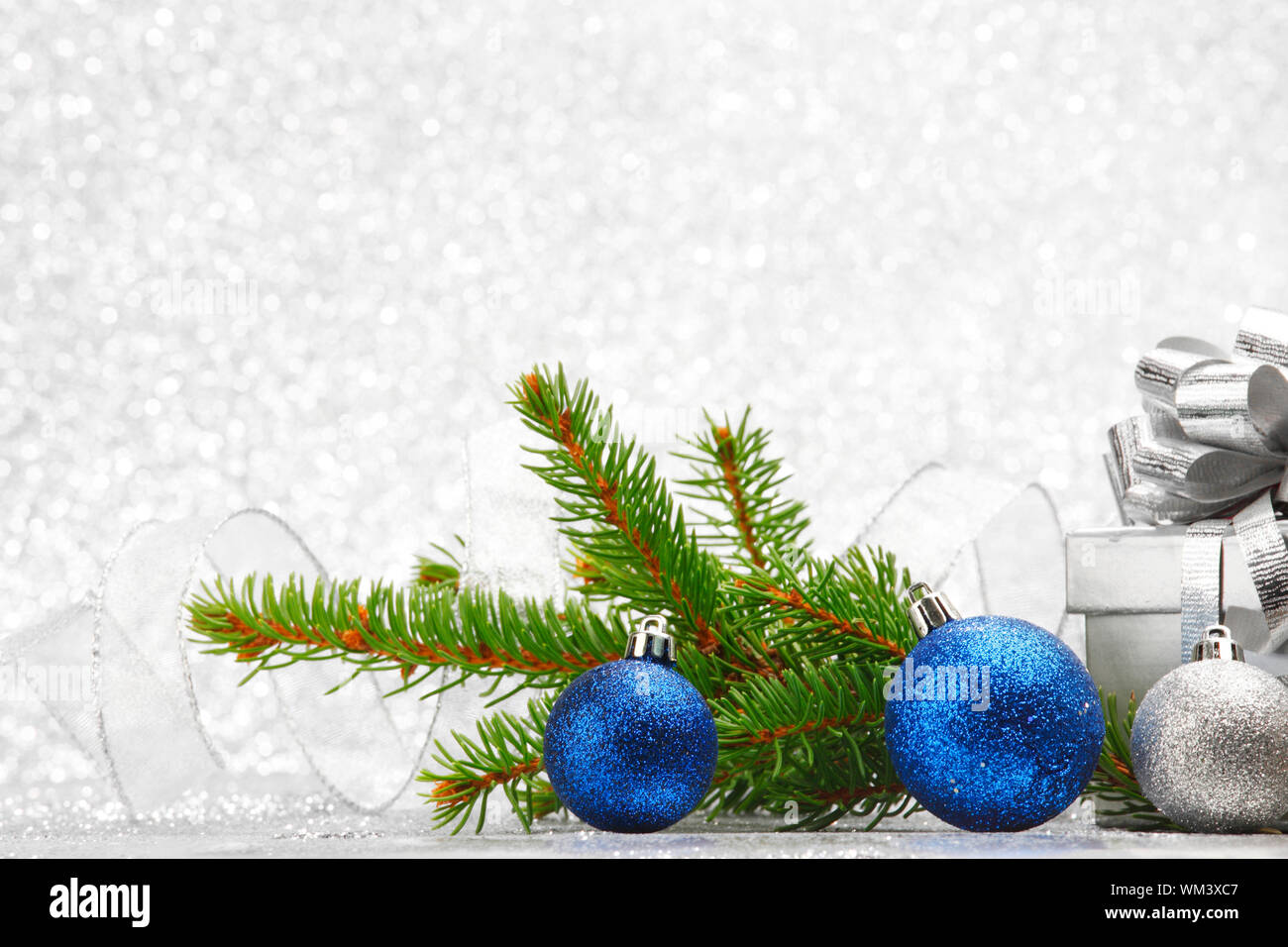 Christmas fir tree branch and decoration on silver glitter background ...