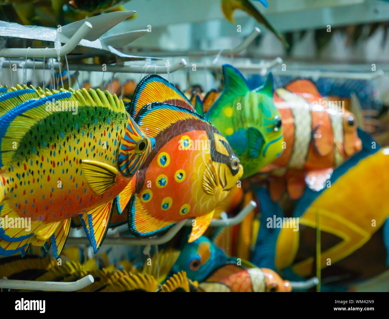 Colorful souvenir background. Hanging decoration in the market. Handmade fish hanging on the