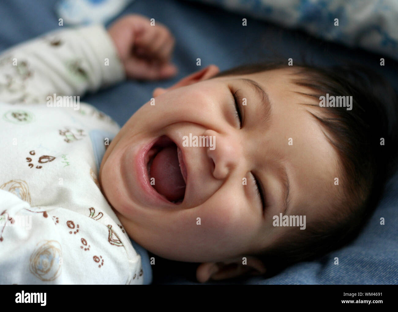 Happy six month old baby on bed Stock Photo