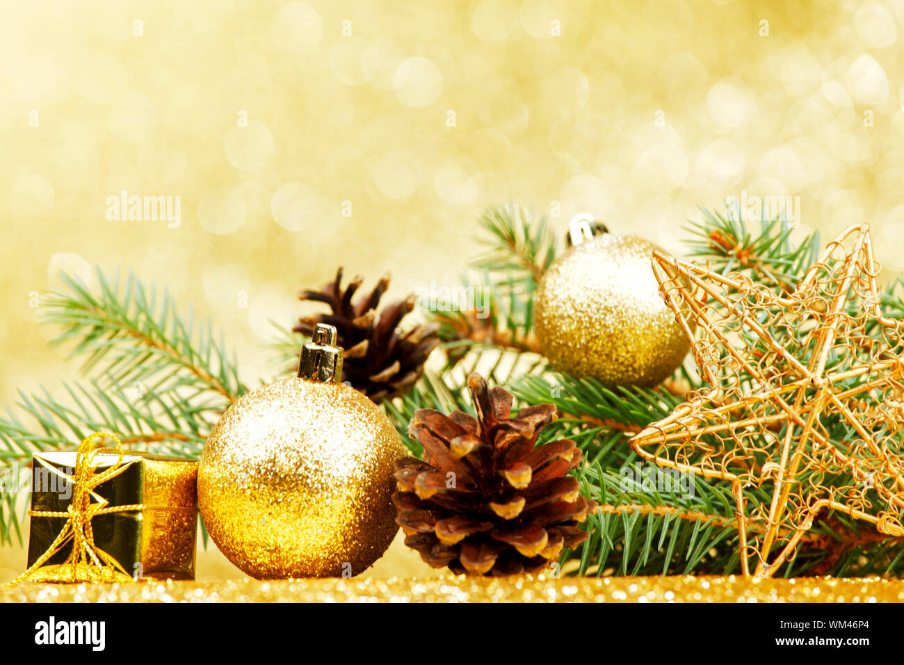 Christmas card with fir tree branch and decoration on golden glitter ...