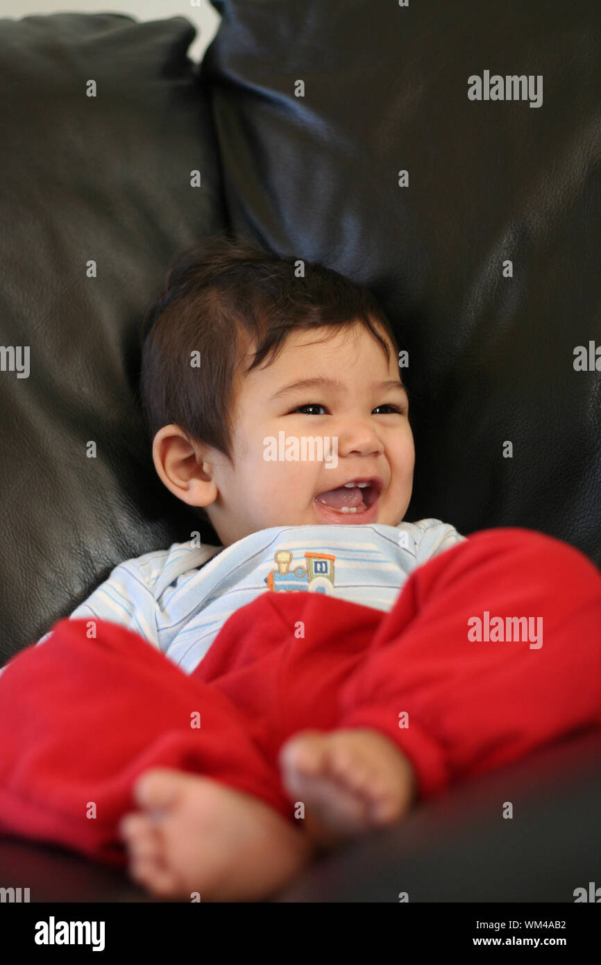 Baby boy relaxing on couch Stock Photo Alamy