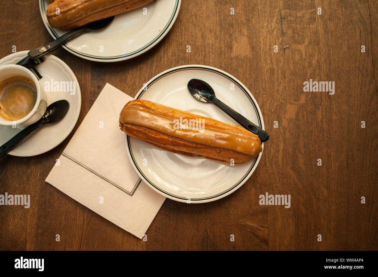 High Angle View Of Eclair In Plate On Wooden Table Stock Photo