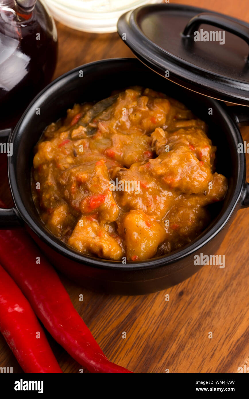 homemade hot goulash on wooden table Stock Photo