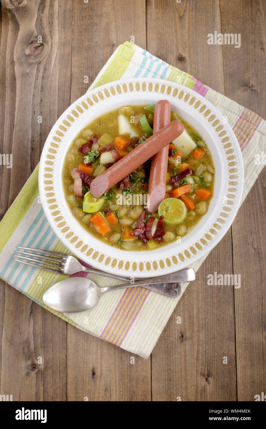 pea soup with sausages, carrott, potato celery in a soup plate Stock Photo