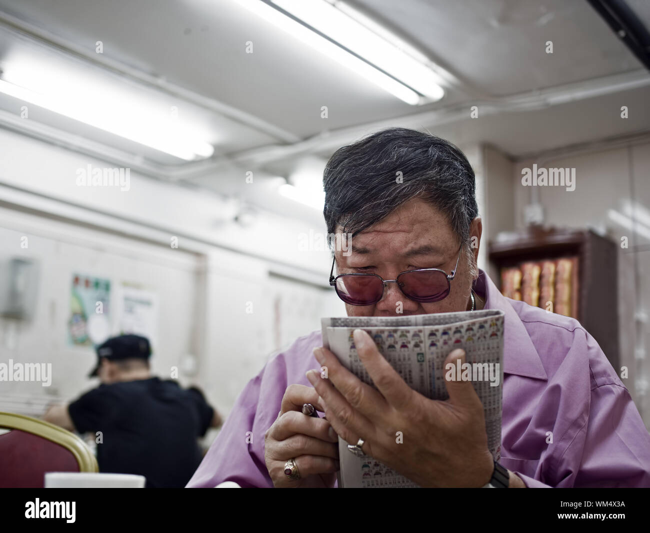 Cheung Chau HONG KONG - November 9 2014 - Horse racing gambler studing ...