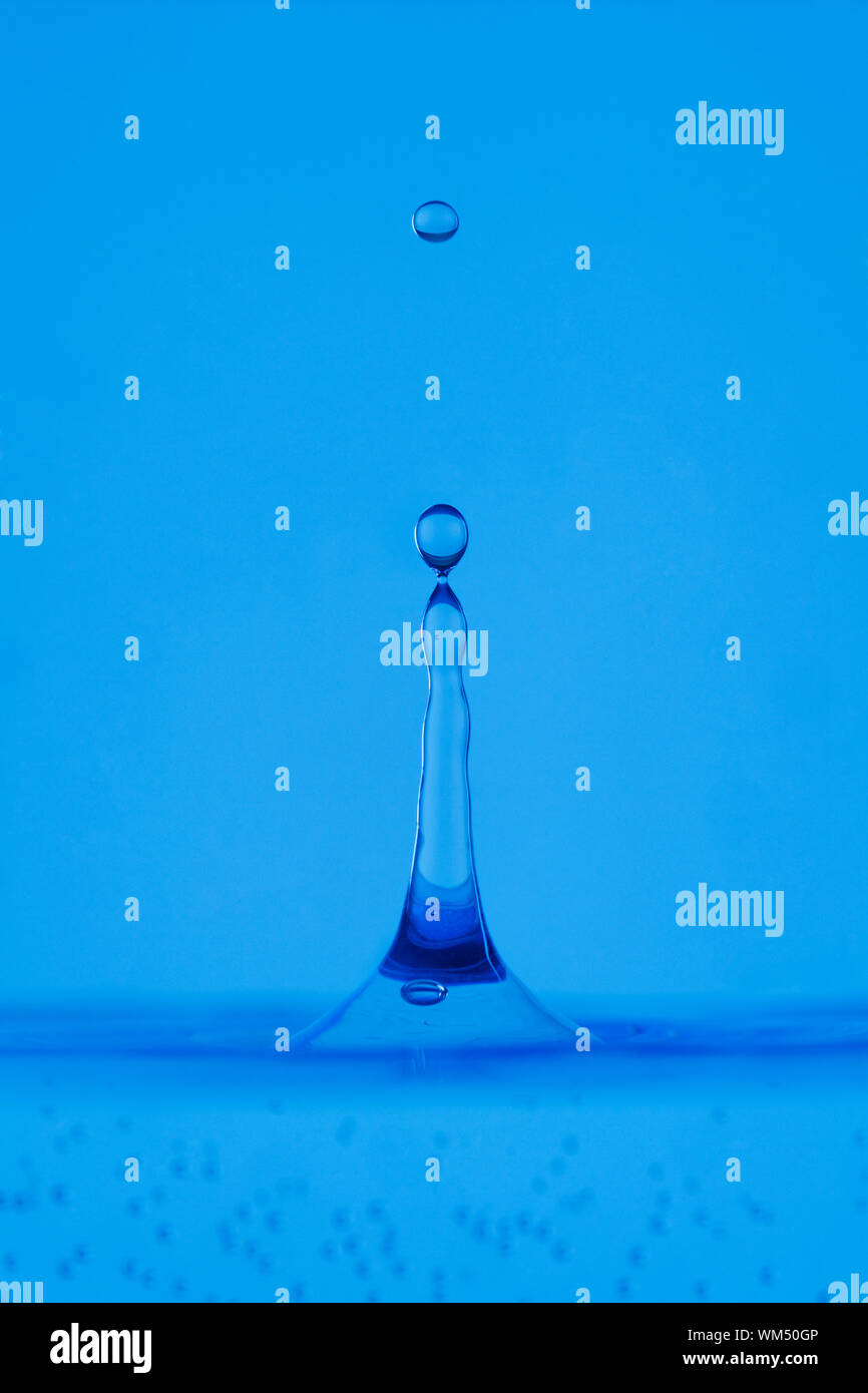blue droplet hitting the water surface splashing it up Stock Photo - Alamy