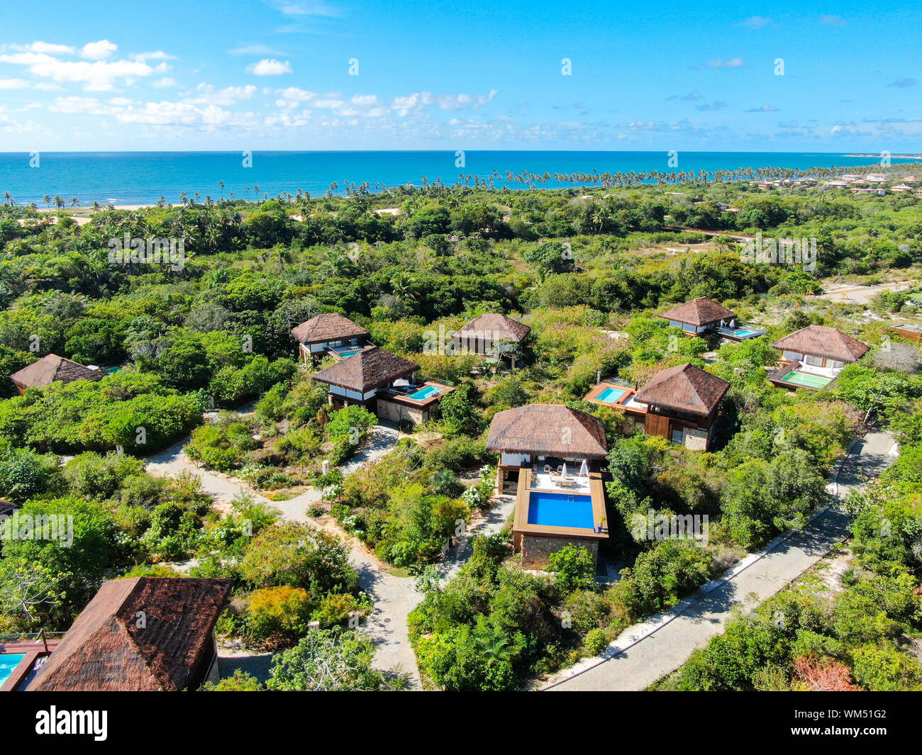 Aerial view of luxury villa with swimming pool in tropical forest. Private tropical villa with swimming pool among tropical garden with palm trees Stock Photo
