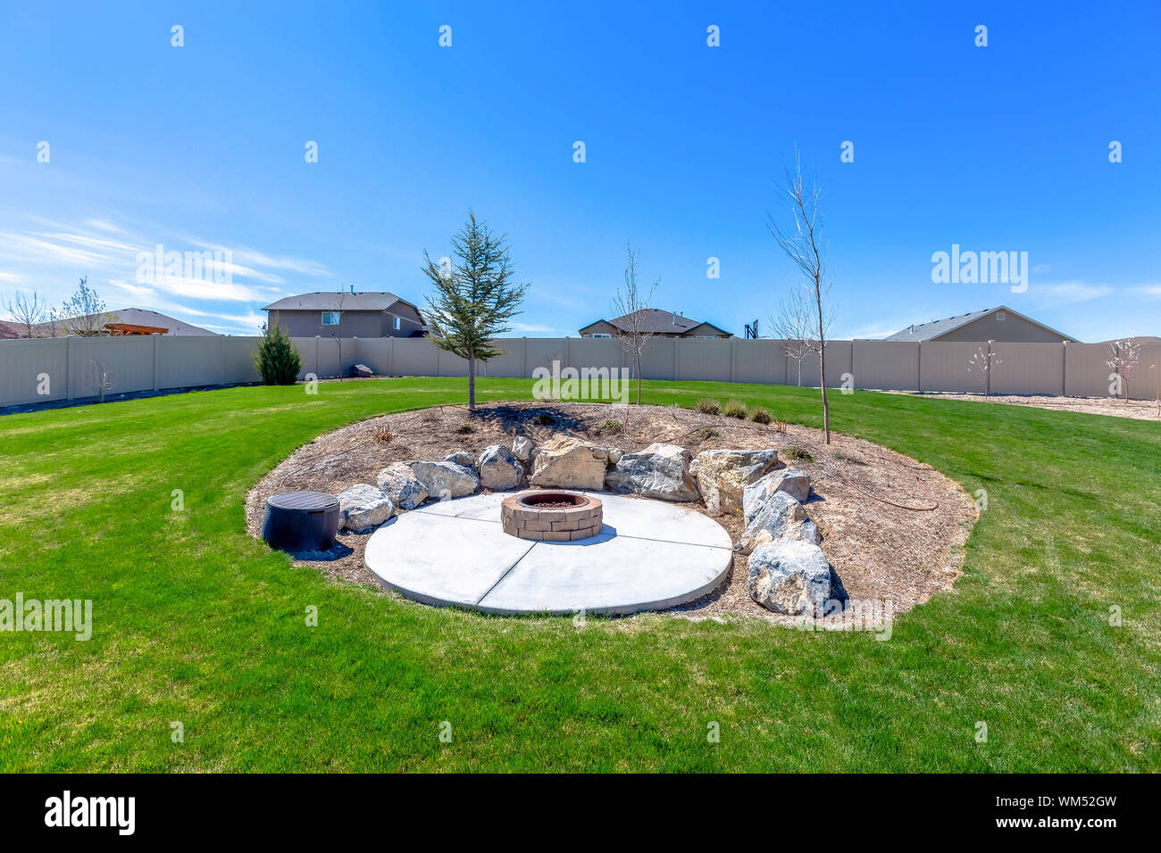 Circular Fire Pit Surrounded By Rocks In The Middle Of The Grassy