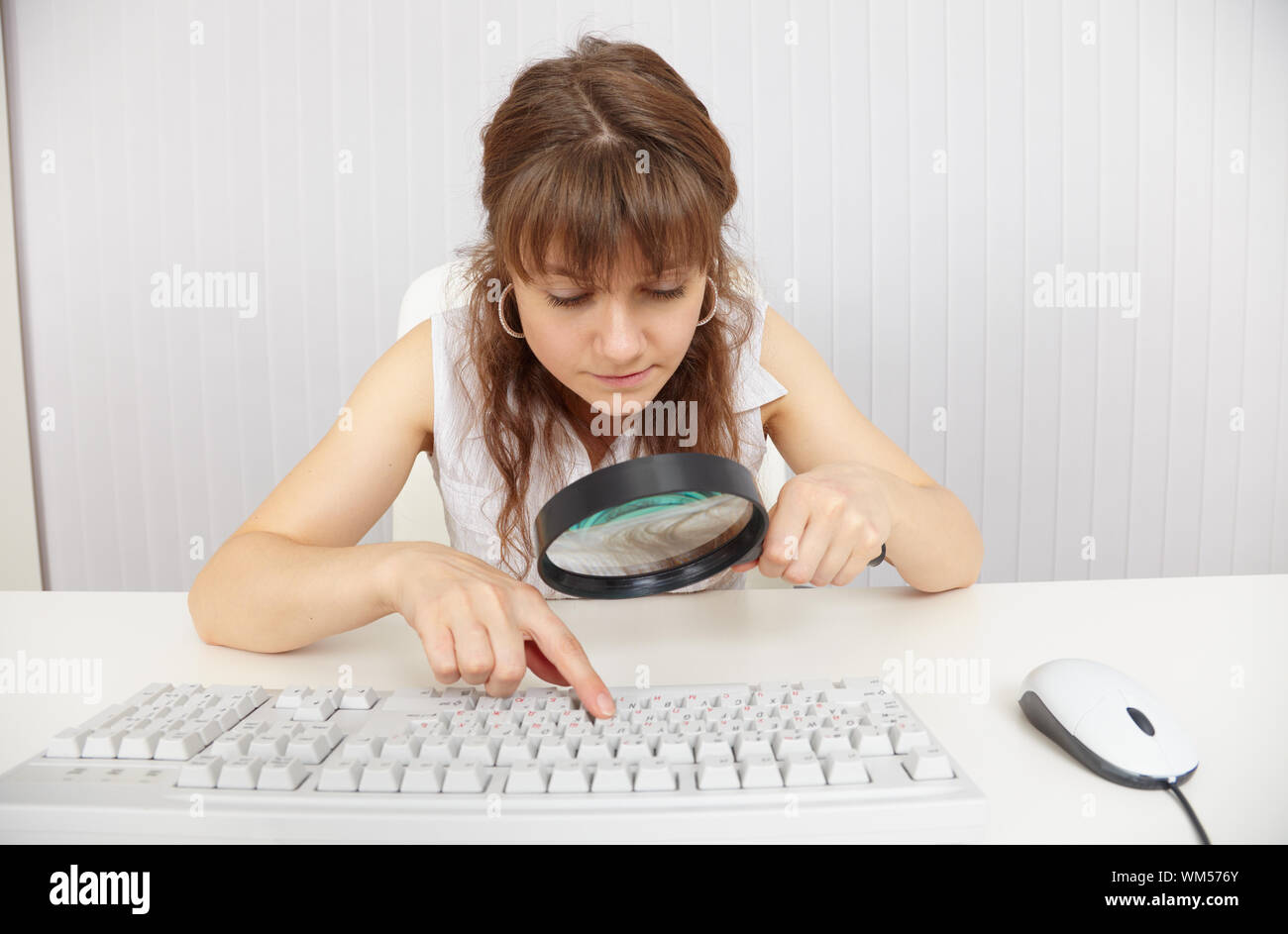 The young blind woman works with the keyboard by means of a magnifier ...