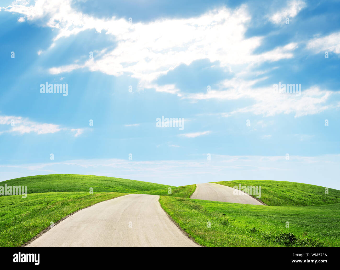 Road running through green hills towards horison Stock Photo