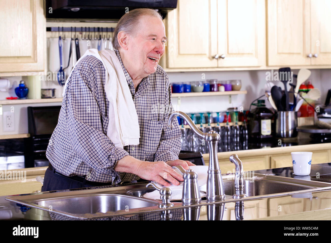 Elderly man washing dishes Stock Photo Alamy