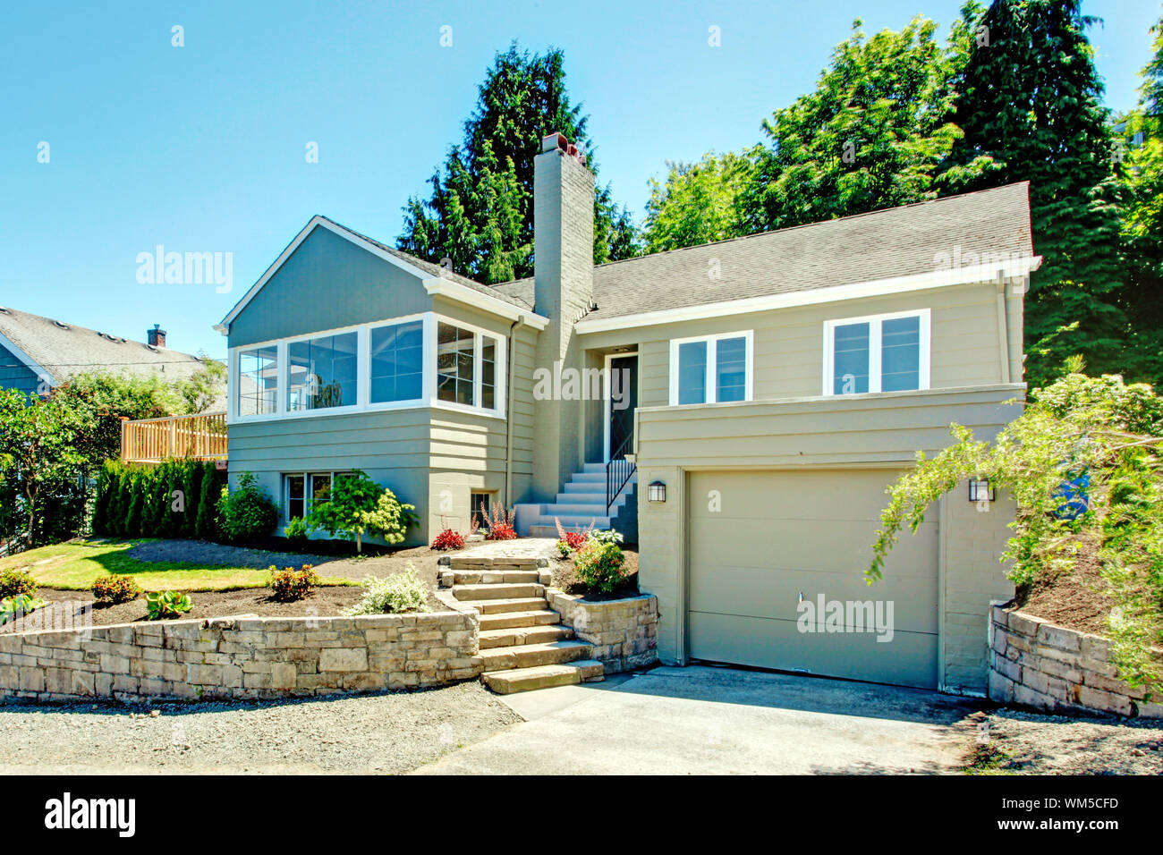 House exterior in clapboard siding. House with garage, driveway and