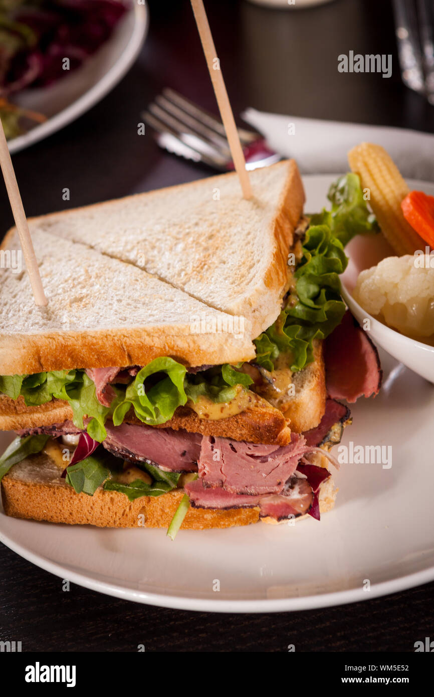 Delicious pastrami club sandwich and pickles Stock Photo Alamy
