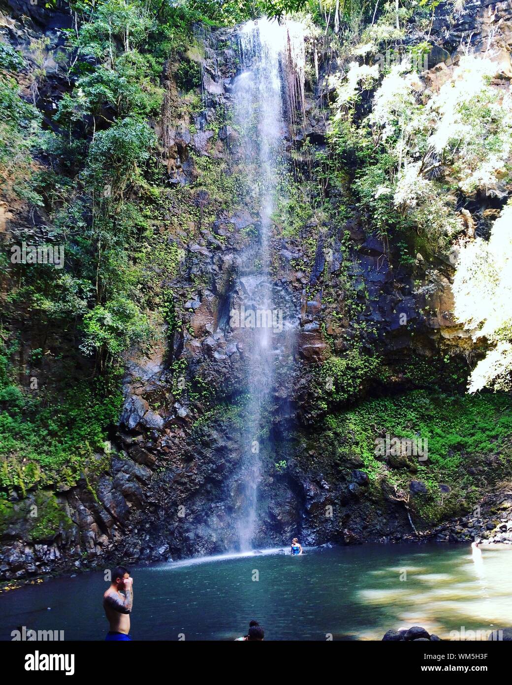 People Enjoying In Waterfall At Kauai Stock Photo