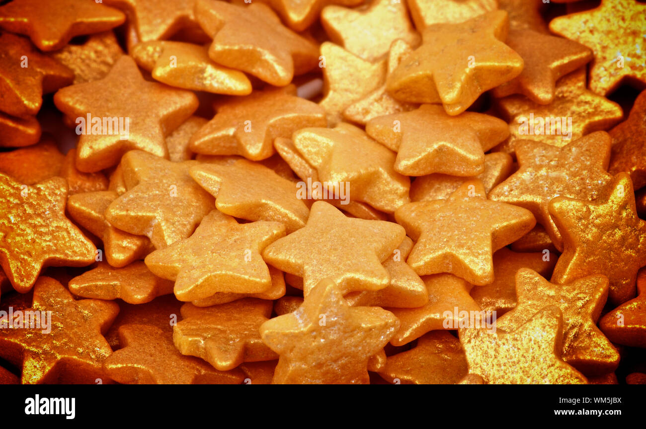 Background of Golden Sugar Stars Dessert Toppings closeup. Focus on Centre Stock Photo