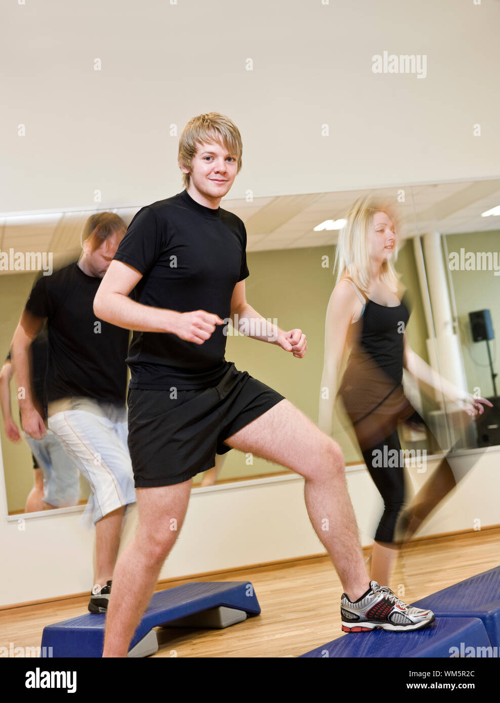 Group of people doing step up with a boy in focus Stock Photo - Alamy