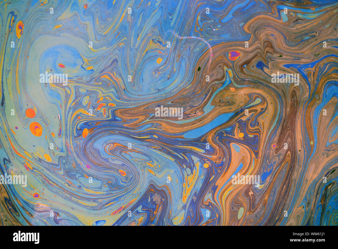 Toxic colours of oil and water in a chemical spill creating a psychedelic blur of rainbow colours. Copyspace area for environmental and pollution base Stock Photo