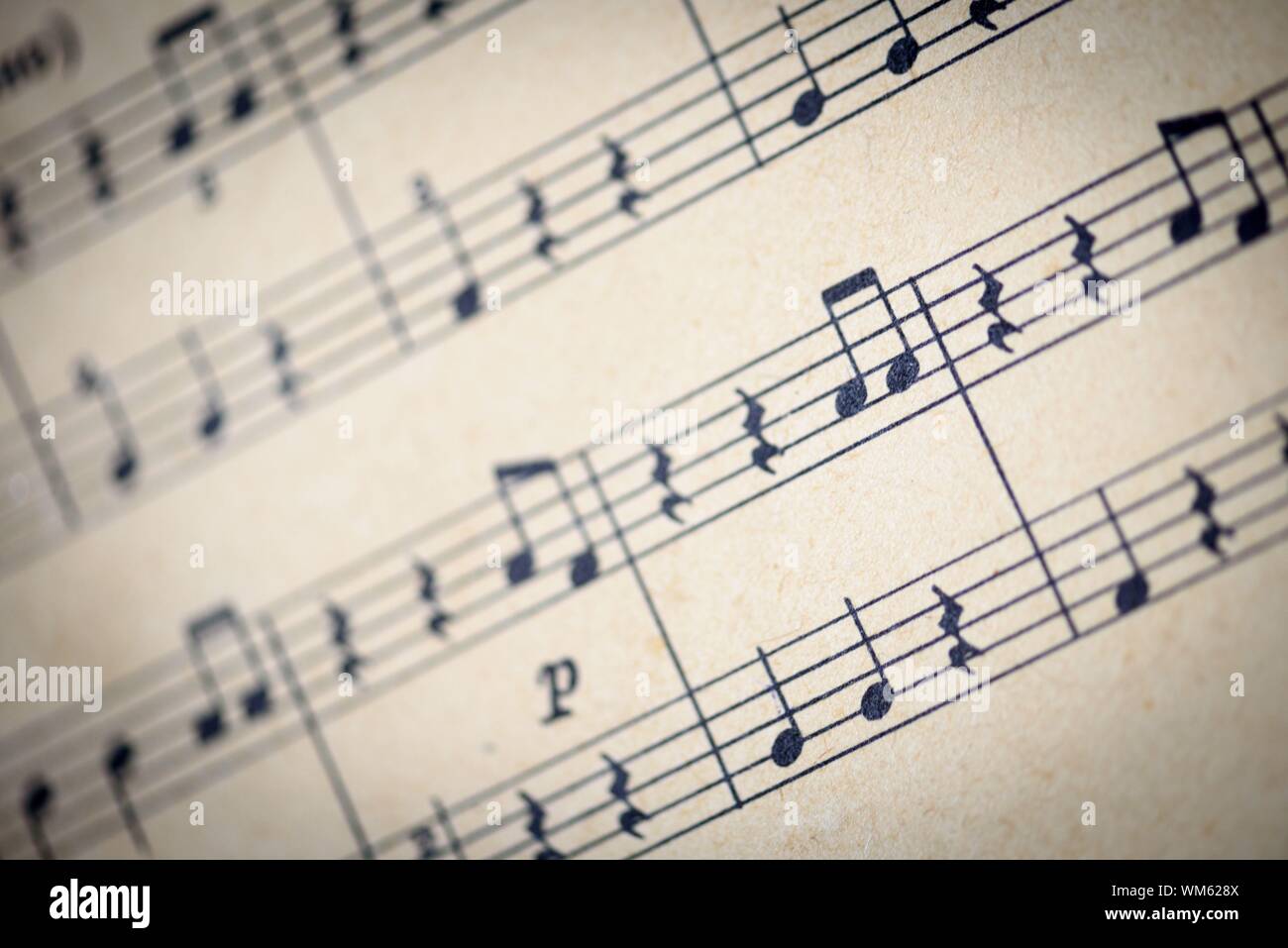 Aged sepia effect of a macro closeup shot of musical notes written on paper notes in traditional sheet music format Stock Photo