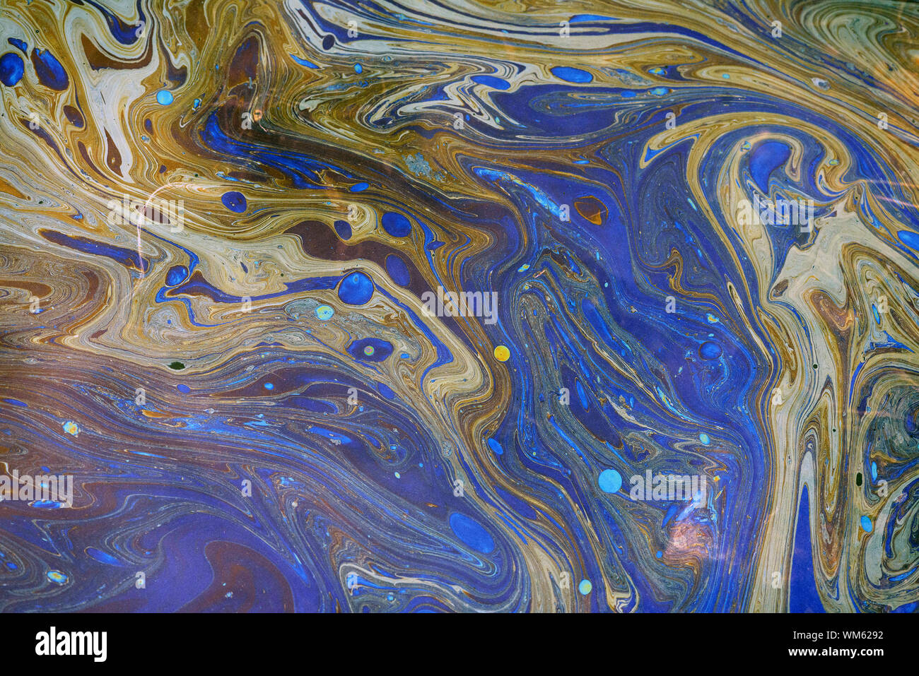 Toxic colours of oil and water in a chemical spill creating a psychedelic blur of rainbow colours. Copyspace area for environmental and pollution base Stock Photo