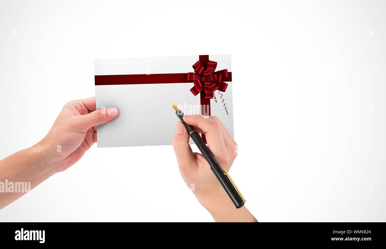 Hands holding card and pen against red christmas bow and ribbon Stock Photo - Alamy