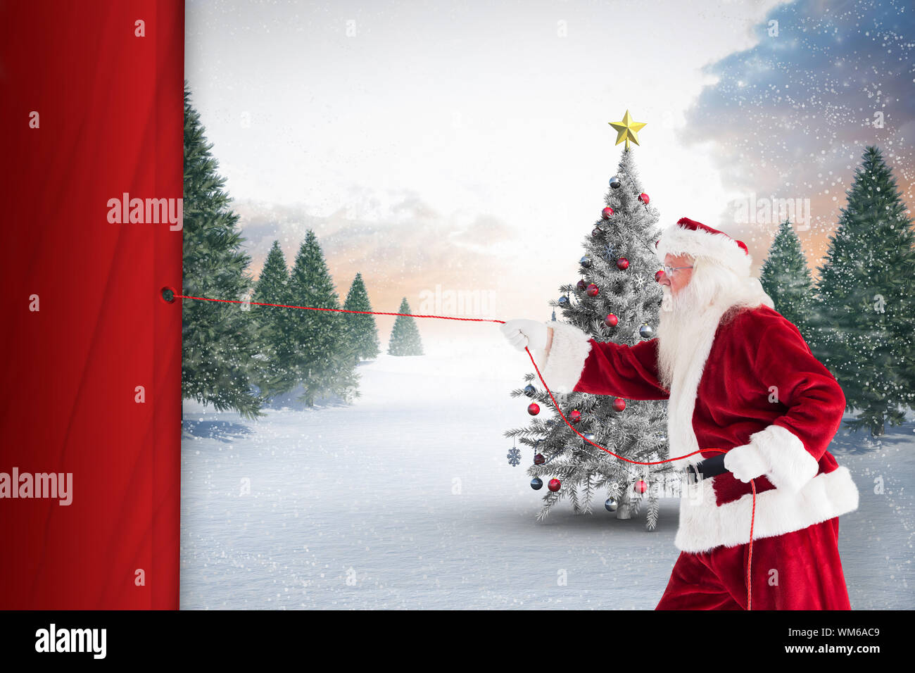 Santa pulls something with a rope against christmas tree in snowy ...