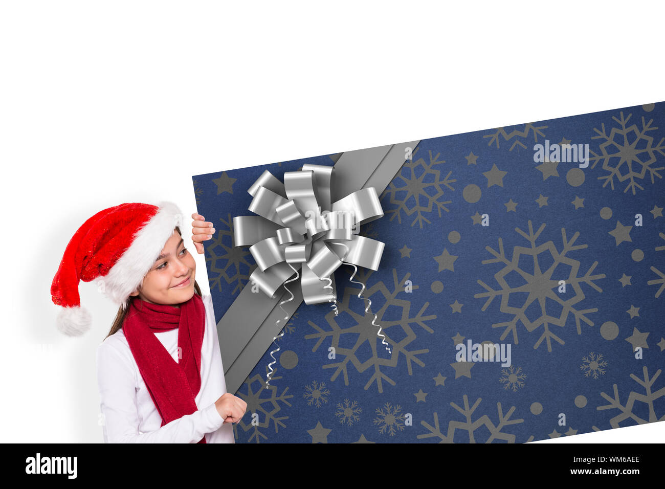 Festive little girl showing card against christmas wrapping paper with bow Stock Photo - Alamy