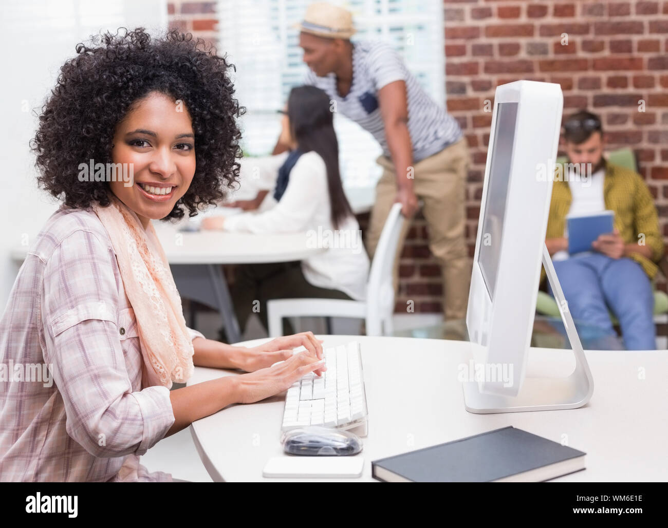 Portrait of casual young woman using computer in the office Stock Photo ...