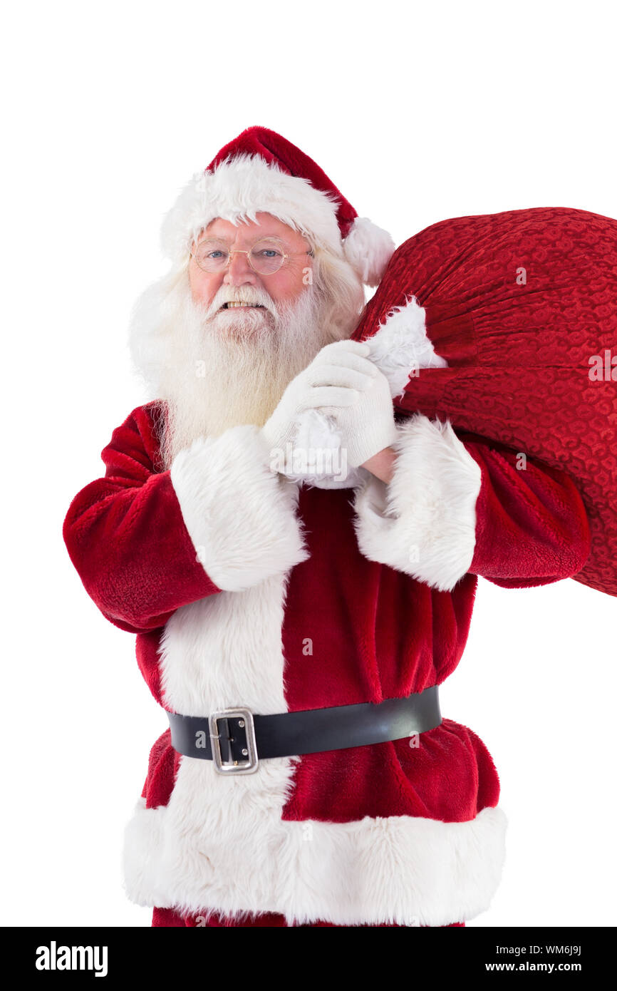Santa carries his red bag an smiles on white background Stock Photo - Alamy