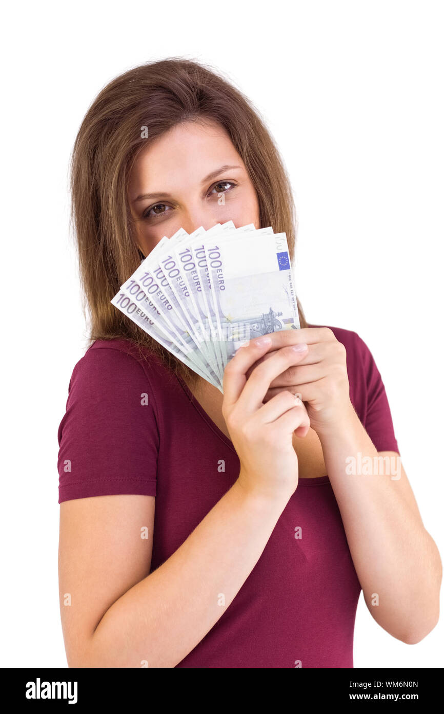Festive brunette holding her cash on white background Stock Photo - Alamy