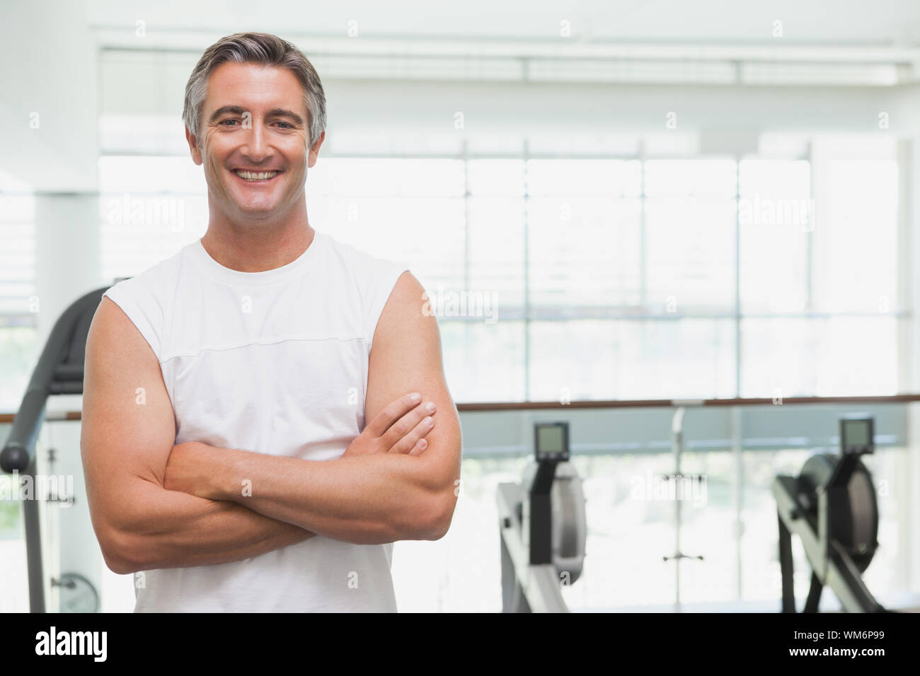 Fit man smiling at camera in fitness studio at the gym Stock Photo - Alamy