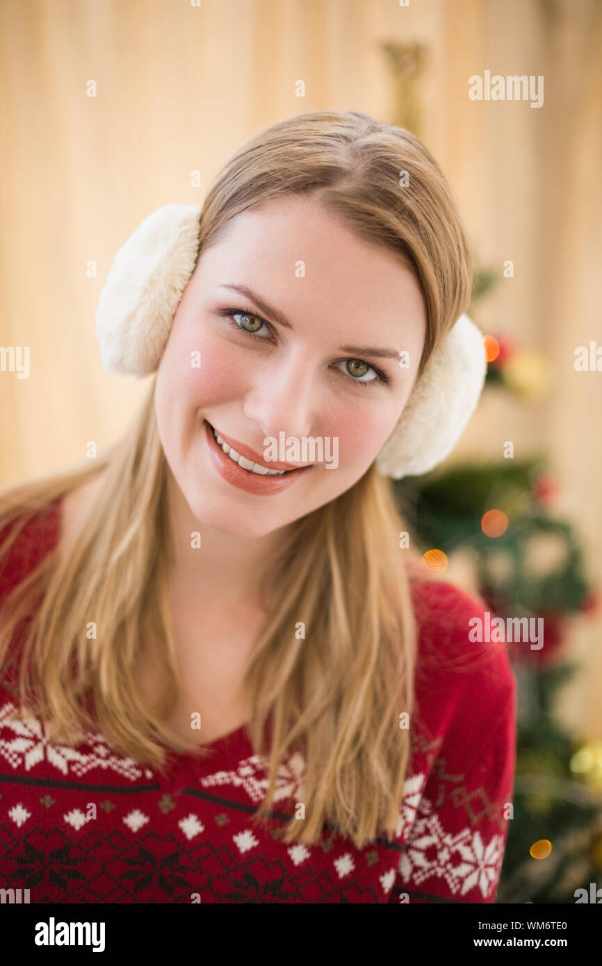 Portrait of a smiling blonde wearing earmuffs at home in the living room Stock Photo