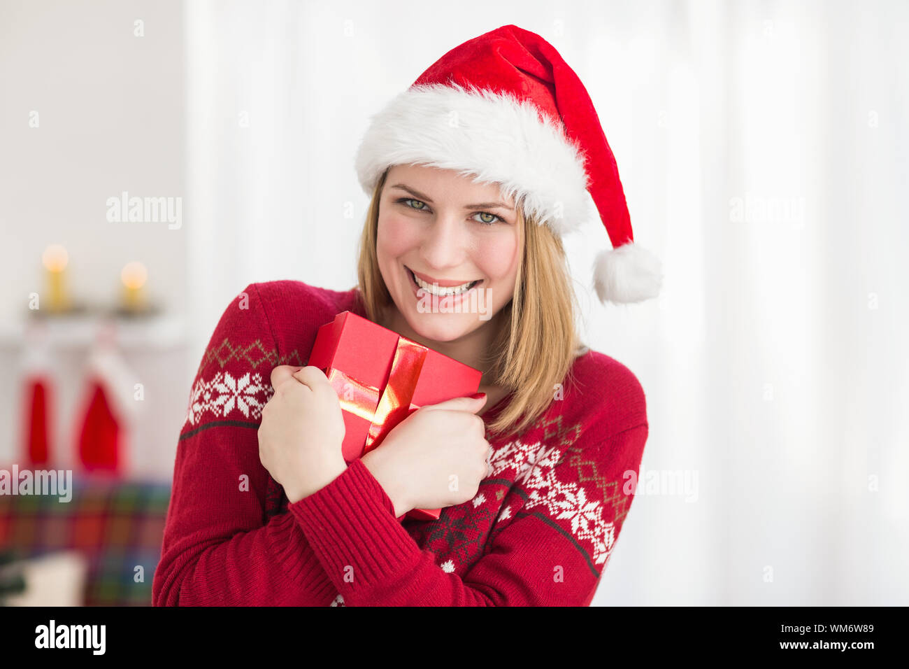 Festive pretty woman hugging her gift at home in the living room Stock ...