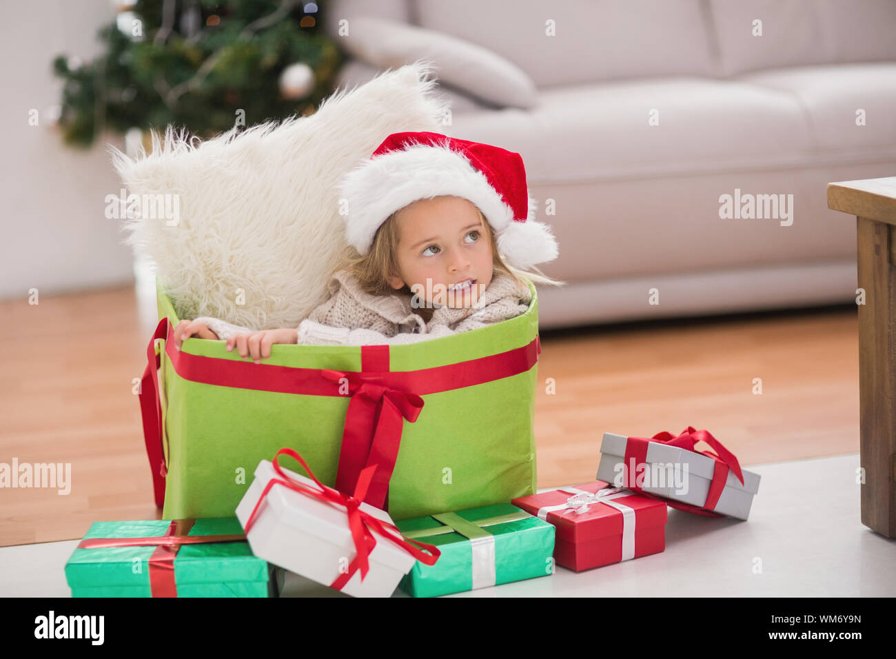 Cute little girl sitting in giant christmas gift at home in the living ...