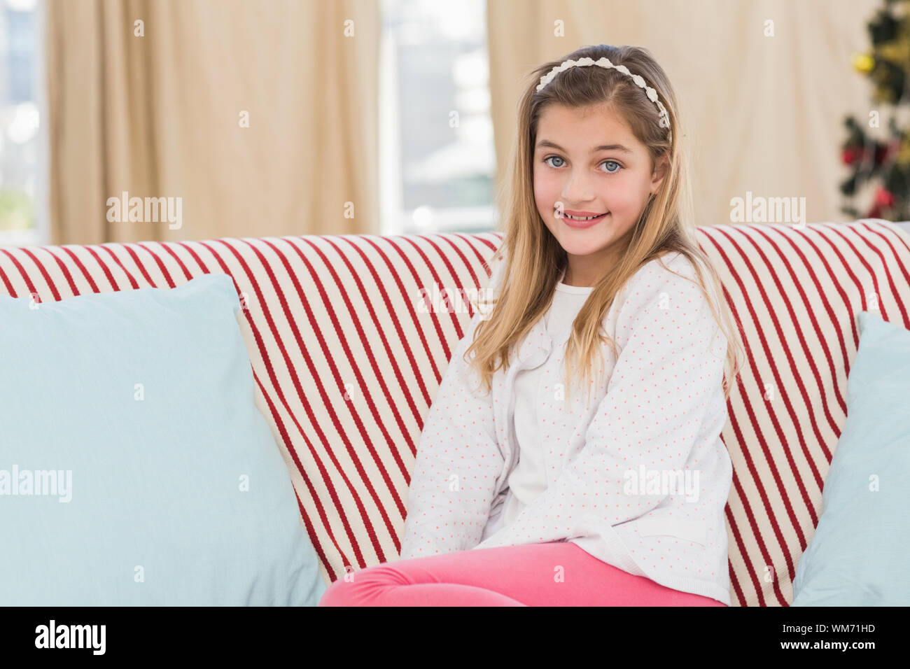 Cute little girl sitting on couch at home in the living room Stock ...