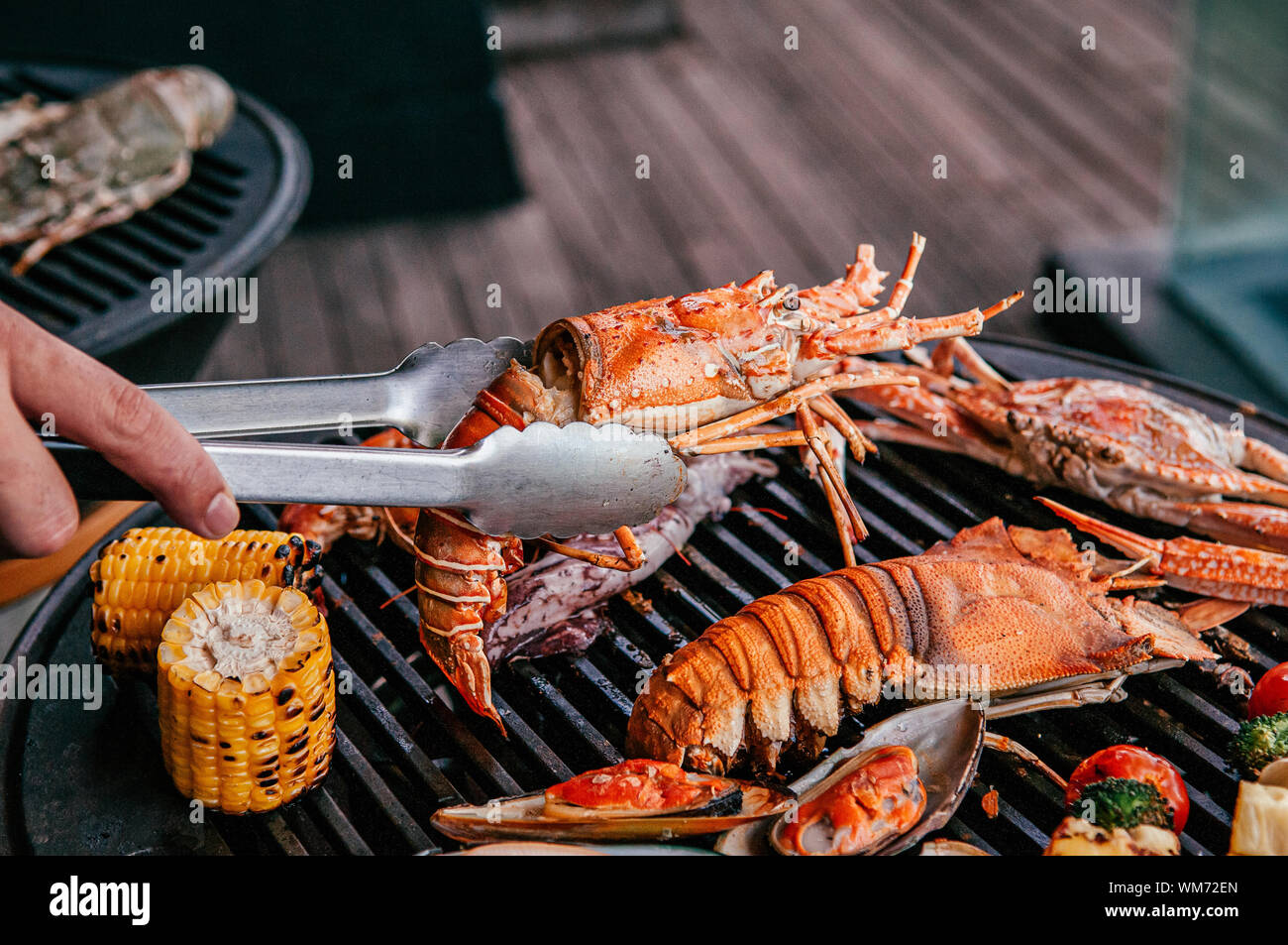 Lobster, rock lobster and mix seafood barbecue cokking on grill - seafood dinner party concept Stock Photo