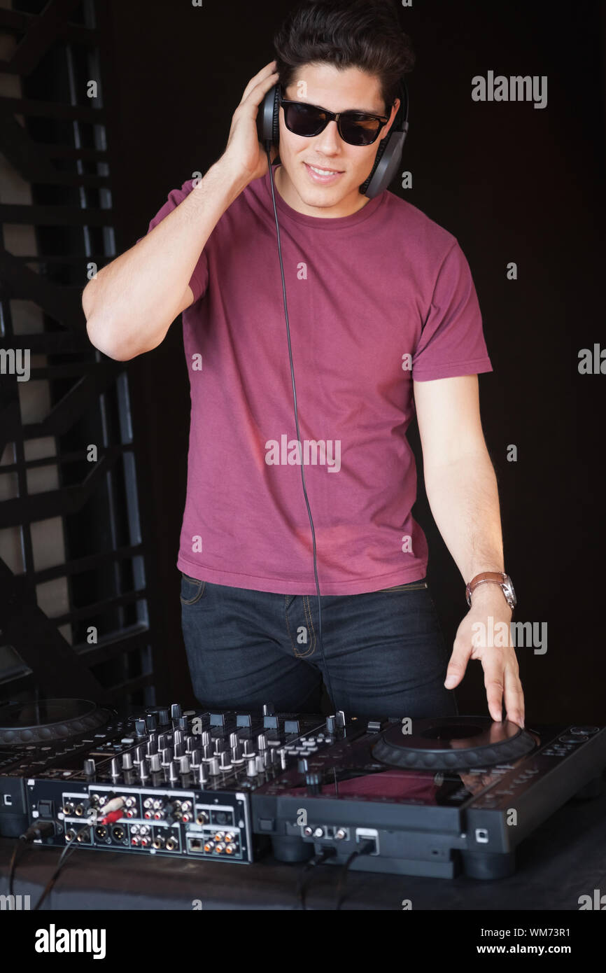Cool dj in sunglasses spinning the decks at the Stock Photo