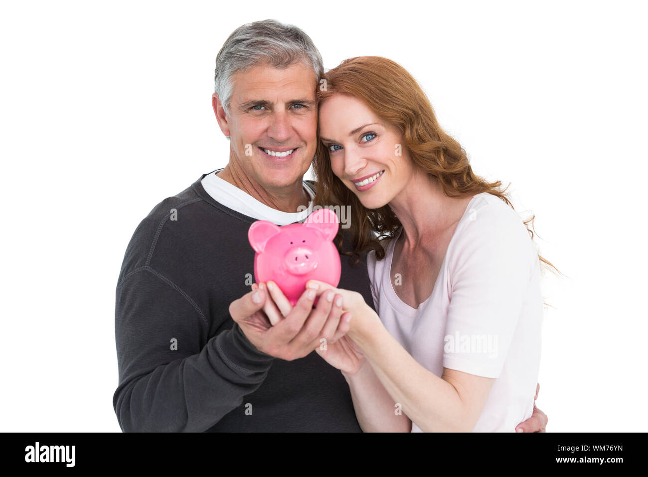 Casual couple showing their piggy bank on white background Stock Photo ...