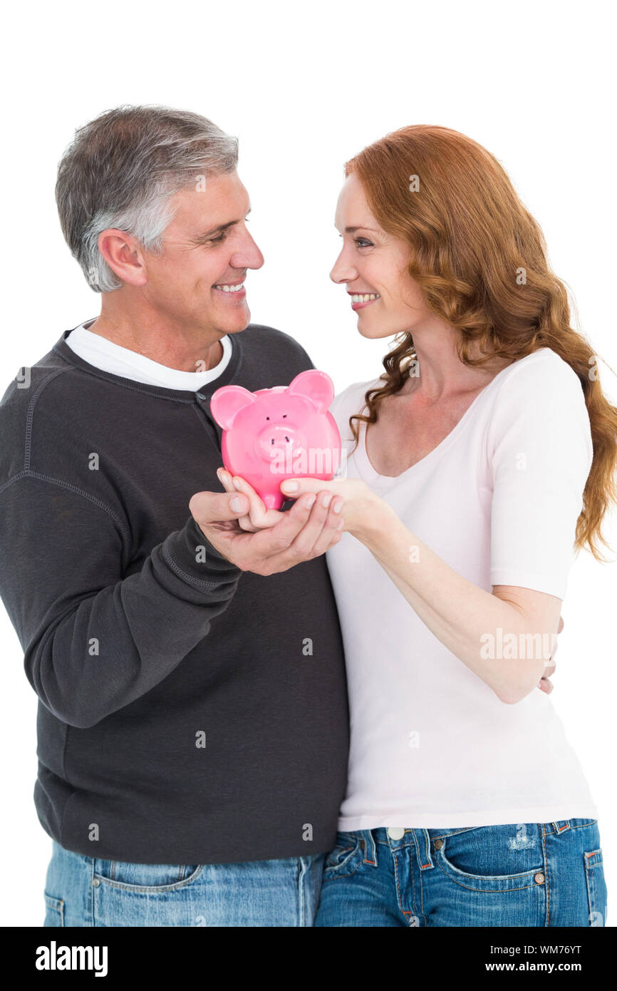 Casual couple showing their piggy bank on white background Stock Photo ...