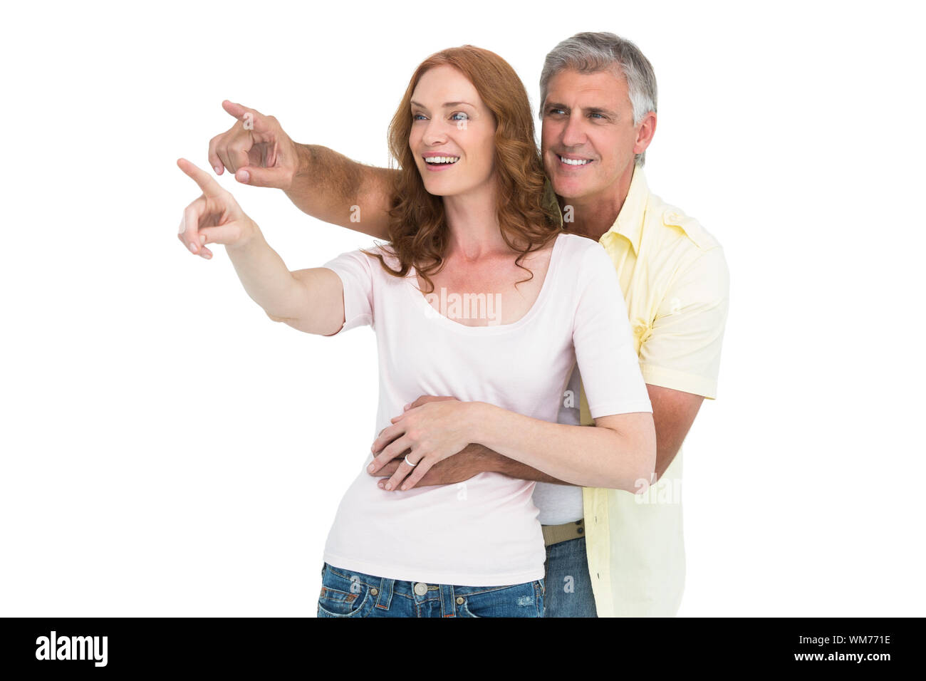 Casual couple smiling and pointing on white background Stock Photo - Alamy