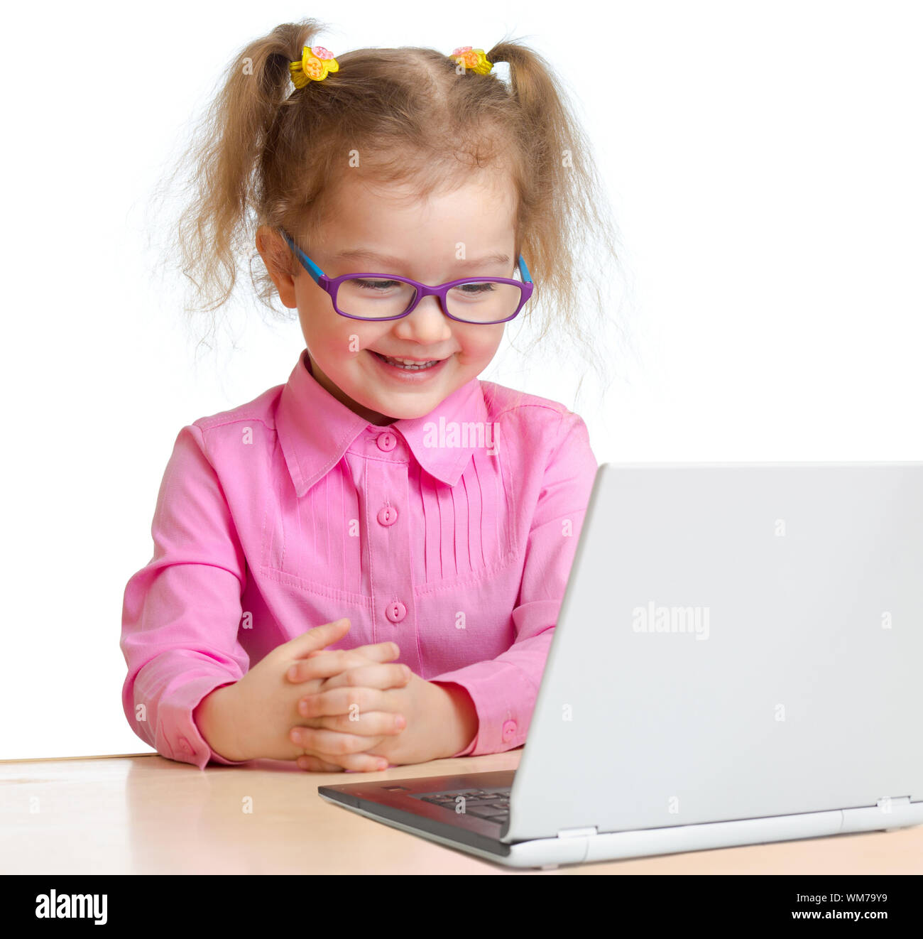 Kid in spectacles reading notebook sitting at table isolate don white Stock Photo