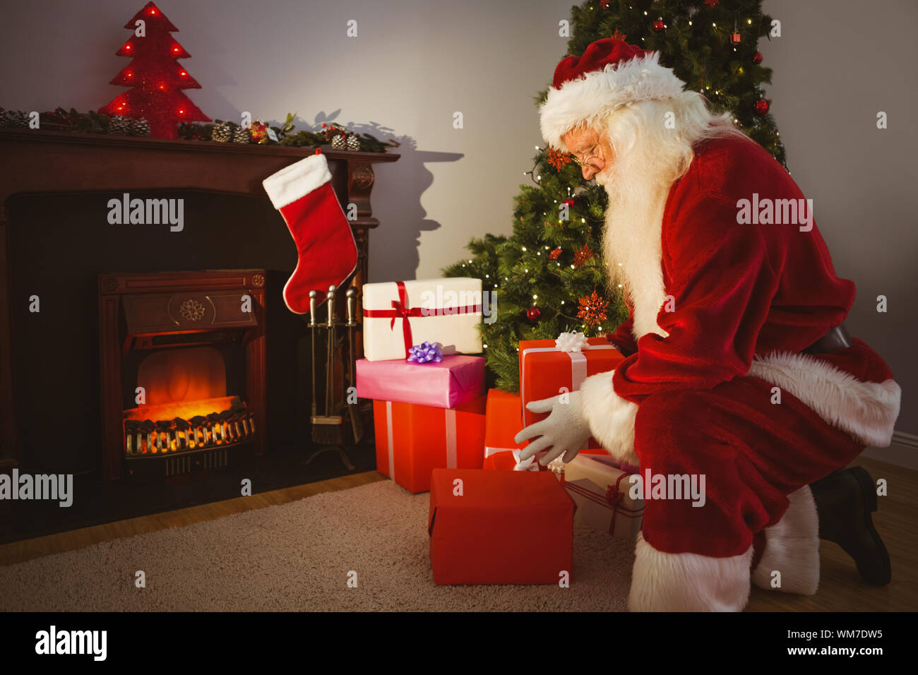 Santa Claus Delivering Gifts At Christmas Eve At Home In The